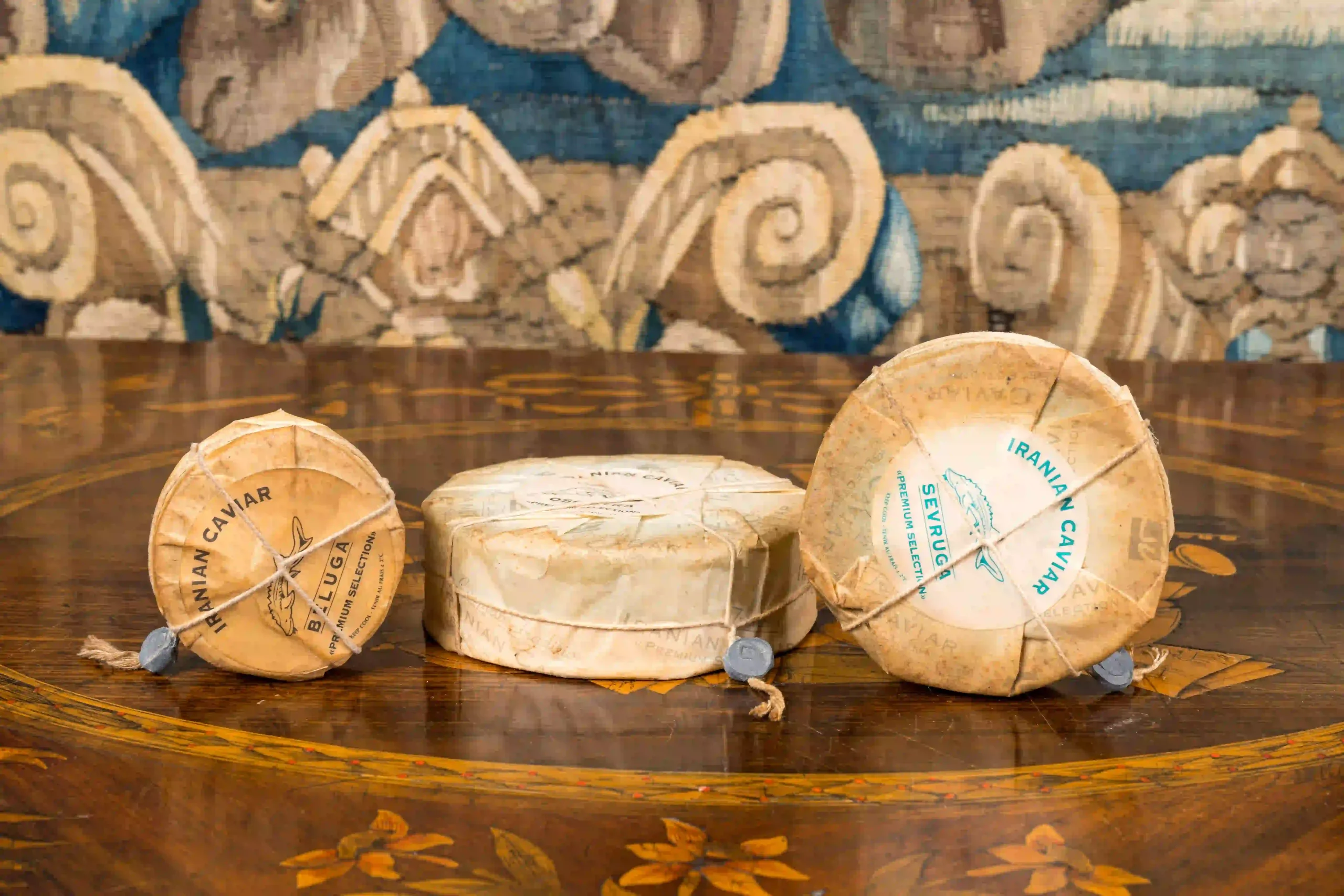 “Three vintage cans of traditional Iranian caviar, sealed and packaged in classic style, showcasing historic packaging methods.” “Old-fashioned cans of Iranian caviar, displaying traditional sealing and packaging techniques used in historical Iran.” “Set of three antique caviar cans from Iran, featuring traditional packaging and sealing methods.”